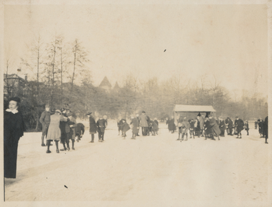 879318 Afbeelding van schaatsende mensen op een ijsbaan, vermoedelijk in het Wilhelminapark te Utrecht, met op de ...